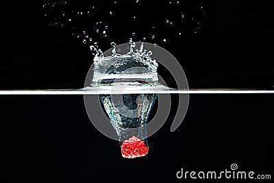 Raspberry falls deeply under water with a big splash. Stock Photo