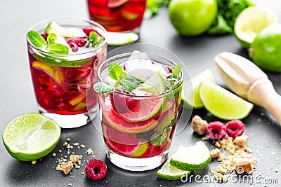 Raspberry mojito cocktail with lime, mint and ice, cold, iced refreshing drink or beverage closeup Stock Photo