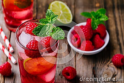 Raspberry Mojito Lemonade with lime and fresh mint in glass on wooden background Stock Photo