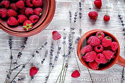 Raspberry in pottery and lavender flowers on rustic background t Stock Photo