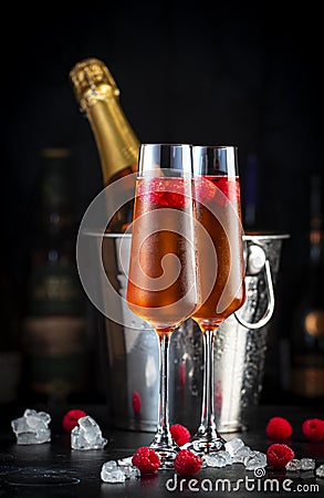 Raspberry Rossini alcoholic cocktail drink with prosecco, cava, or sparkling wine with raspberry puree and ice, dark bar counter Stock Photo