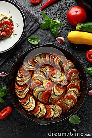 Ratatouille Vegetable Stew with zucchini, eggplants, tomatoes, garlic, onion and basil. on cast iron pan. Traditional Stock Photo