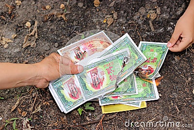 Ratchaburi, Thailand - April 4, 2017 : Burning of fake money made from paper materials during Chinese Qing ming Festival in Cemete Editorial Stock Photo