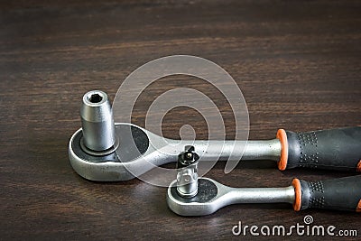 Ratchet wrench lying on wooden table Stock Photo