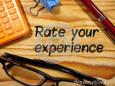 Rate your experience,text on wooden with calculator,pen,paper clips and glasses. Stock Photo