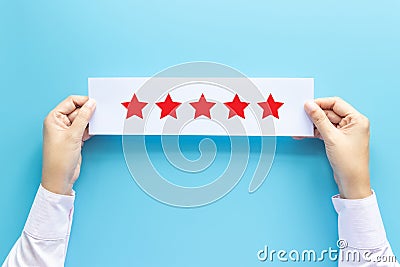 Rating and feedback concept. customer holding paper with satisfied review by give five star for service experience Stock Photo