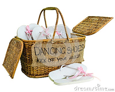Rattan basket with white flip-flops with pink ribbon bows for guests, with a writing DANCING SHOES. KICK OFF YOUR HEELS! Stock Photo