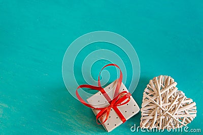 Rattan Woven White Decorative Heart Elegant Gift Bow Tied with Red Ribbon Bow on Painted Turquoise Background Valentine Mother`s Stock Photo