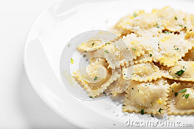 Ravioli with basil and parmesan on a white plate. White wine. Copy space. Close. Italian Cuisine Stock Photo