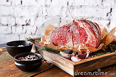 Raw aged prime black angus beef in craft papper on rustic wood Stock Photo