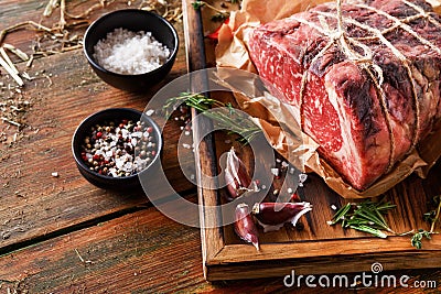 Raw aged prime black angus beef in craft papper on rustic wood Stock Photo