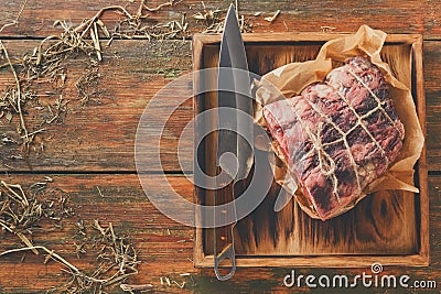 Raw aged prime black angus beef in craft papper on rustic wood Stock Photo