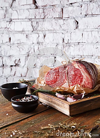 Raw aged prime black angus beef in craft papper on rustic wood Stock Photo