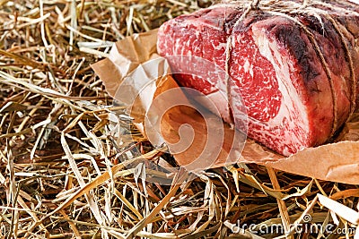 Raw aged prime black angus beef in craft papper on straw Stock Photo