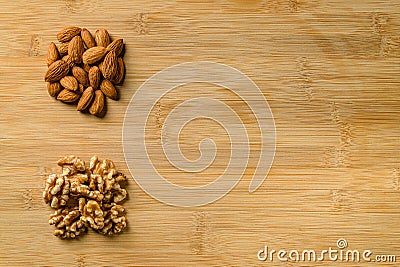 Raw almonds and walnut halves on the wooden cutting board background Stock Photo