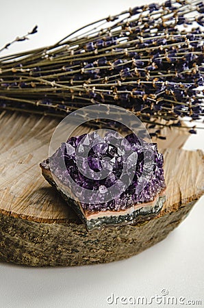 Raw amethyst rock with bunch of aromatic lavender flowers on natural wood rustic esoteric Stock Photo