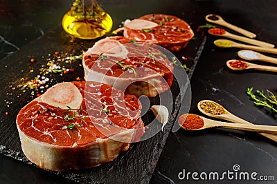 Raw beef shank and spices for preparing ossobuco dish on black background Stock Photo