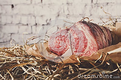 Raw aged prime black angus beef in craft papper on straw Stock Photo