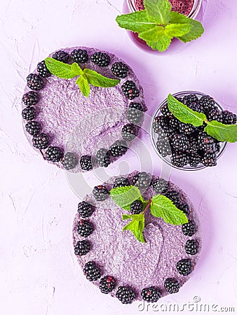 Raw blackberry dessert decorated with fresh ripe forest berries and green mint leaves and blended smoothie. Stock Photo