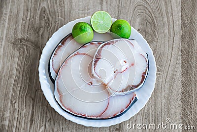 Raw blue shark meat and lime on white plate Stock Photo