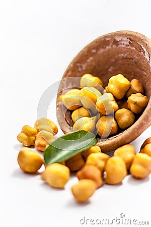 Raw bright dark brown colored Desi chana or original chickpea in a glass bowl isolated on white. Stock Photo