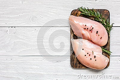 Raw chicken breast fillets on wooden cutting board with herbs and spices Stock Photo