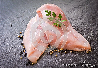 Raw chicken breast with herbs and spices on black plate - Raw uncooked chicken meat marinated with ingredients for cooking Stock Photo