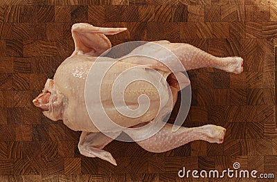 Raw chicken on a chopping board ready to be prepared for cooking. Top view image on wooden background Stock Photo