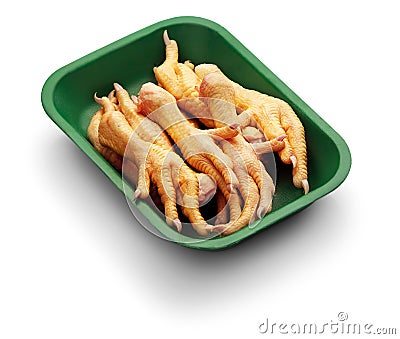 Raw chicken claw in a green tray over white background Stock Photo