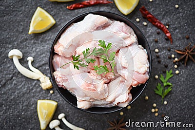 Raw chicken wings with lemon chilli herbs and spices and mushroom on black plate top view - Raw uncooked chicken meat marinated Stock Photo