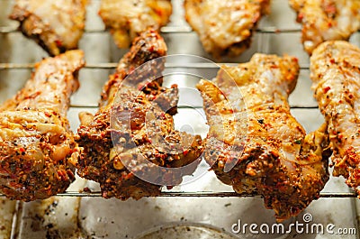 Raw chicken wings with a rendang style rub made with chilli and garlic on the grill tray Stock Photo