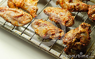 Raw chicken wings with a rendang style rub made with chilli and garlic on the grill tray Stock Photo