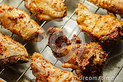 Raw chicken wings with a rendang style rub made with chilli and garlic on the grill tray Stock Photo