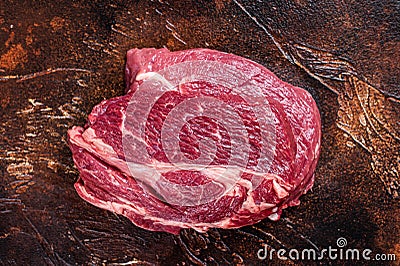 Raw Chuck eye roll beef steak on butcher table. Dark background. Top view Stock Photo