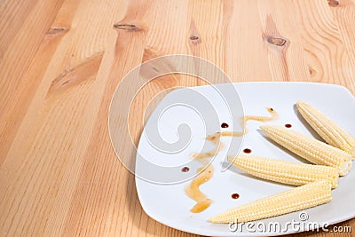 Raw on the cob mini corn on the plate copy space. Horizontal photo format Stock Photo