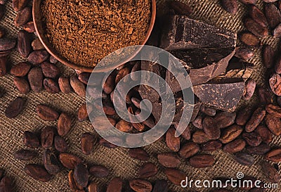 Raw cocoa beans, clay bowl with cocoa powder, chocolate on sack Stock Photo