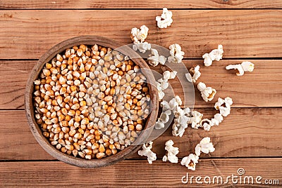 From Kernel to Pop: Raw Corn Seeds and Popped Popcorn on Retro Wooden Table Stock Photo