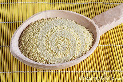 Raw couscous - cuscus on wooden spoon Stock Photo