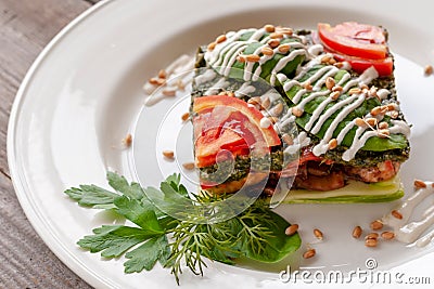 Vegetarian dish: lasagna with zucchini, mushrooms, tomatoes, basil, wheat germ, spinach, garlic. Raw food dish. Stock Photo