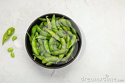 Raw edamame soya beans with salt and sauce on light gray background Stock Photo