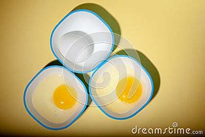 Raw egg & yellow yolk in three bowls Stock Photo