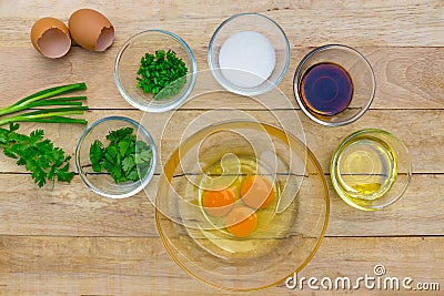 Raw eggs and ingredients on wooden background. Stock Photo