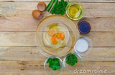 Raw eggs and ingredients on wooden background. Stock Photo