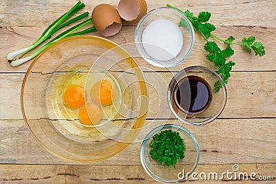 Raw eggs and ingredients on wooden background. Stock Photo