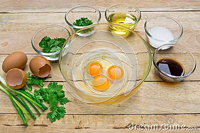 Raw eggs and ingredients on wooden background. Stock Photo