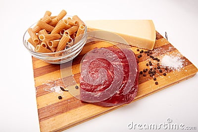 Raw Entrecote steak meat With Pepper and Salt pasta cheese On Wooden Board in a kitchen isolated on white Stock Photo