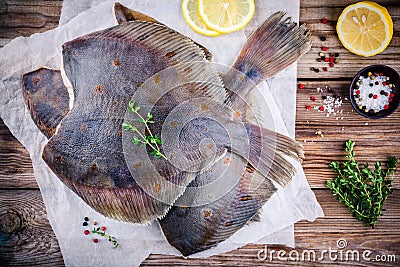 Raw flounder fish, flatfish on wooden table Stock Photo