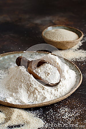 Raw fonio flour and seeds with a spoon on dark background Stock Photo