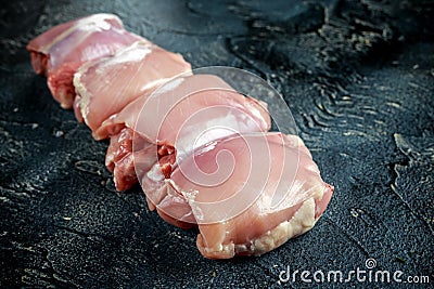 Raw Free range Boneless skinless chicken thighs on stone table Stock Photo