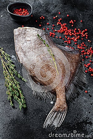 Raw fresh John Dory fish with pink pepper and thyme. Black background. Top view Stock Photo